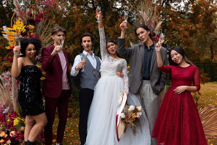 A happy wedding party with a bride, groom, and groomsman celebrating in a garden. A happy wedding party with a bride, groom, and groomsman celebrating in a garden.