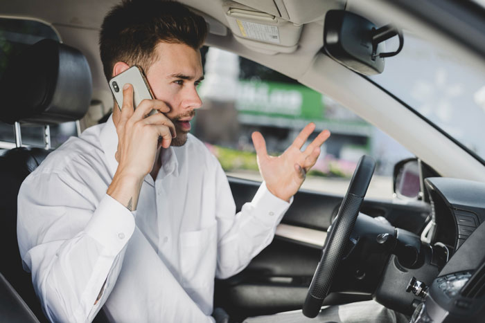 An angry tourist on the phone in a car, expressing frustration about a tour guide starting without them. An angry tourist on the phone in a car, expressing frustration about a tour guide starting without them.