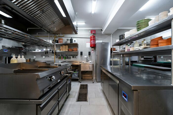 A clean restaurant kitchen with stainless steel appliances, showing places that passed health inspections.