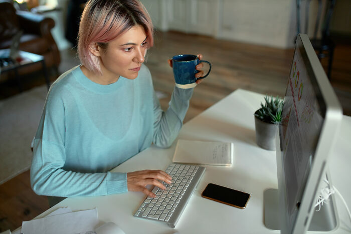 A woman working on a computer, showcasing one of the unpopular industries that actually make millions.
