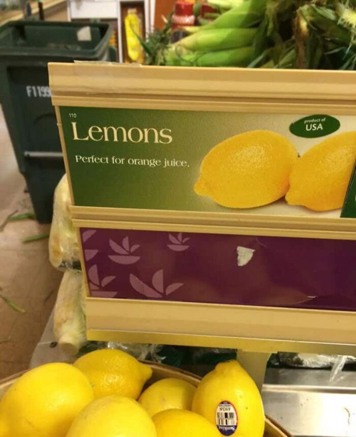 A produce display with a sign for lemons that reads Perfect for orange juice, highlighting a designer's failed job with confusing product information.