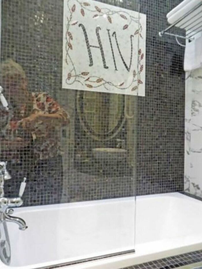 A bathroom with a sign in the shower glass showing the letters HIV, highlighting a design failure.