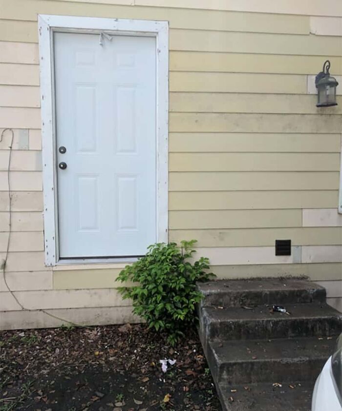 A white door placed too high above a short staircase, revealing a designer's poor e*******n.