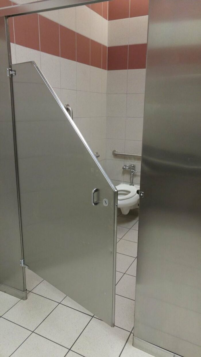 A public toilet stall door that is too short, demonstrating a designer's failure to do their job.
