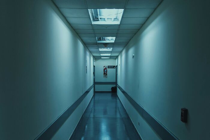 A long, dimly lit hospital corridor, creating a chilling atmosphere for hospital horror stories.