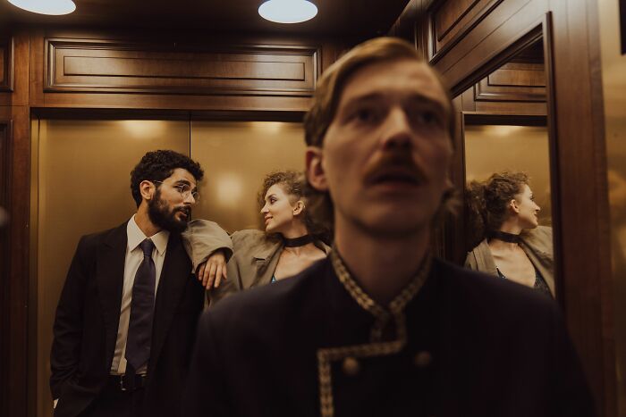 People in a hotel elevator, hinting at helpful hotel industry secrets and the journey of your next vacation.