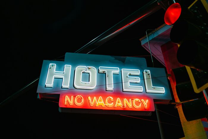 Neon Hotel No Vacancy sign at night, offering helpful hotel industry secrets before your next vacation.