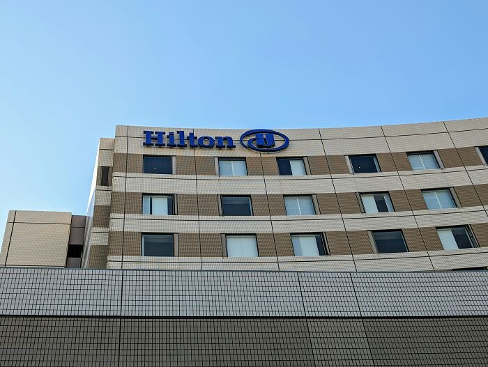 Hilton hotel exterior on a clear day, revealing hotel industry secrets for a vacation.