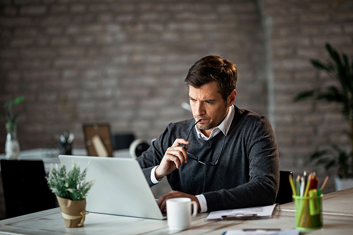 Man carries the family, appearing stressed at a laptop, wondering if he can keep going.