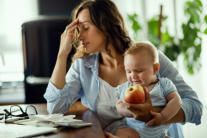 A stressed mother with a baby, representing the challenges that may lead a man to kick his mom out of his home. A stressed mother with a baby, representing the challenges that may lead a man to kick his mom out of his home.