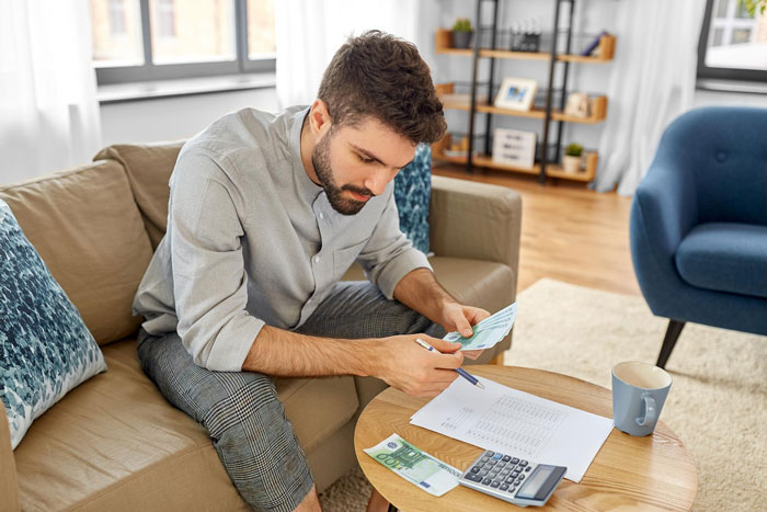 Man counting money, considering his son's long-lost $6K and the finder's fee. Man counting money, considering his son's long-lost $6K and the finder's fee.