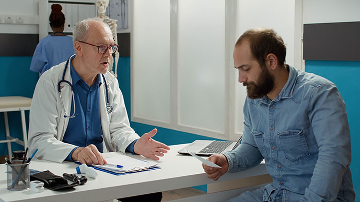 Doctor talking to a man about donating a kidney, discussing important health history. Doctor talking to a man about donating a kidney, discussing important health history.