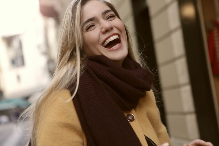 A young woman laughing heartily, showing her joy and pure chaos, perhaps due to an identical twin experience.