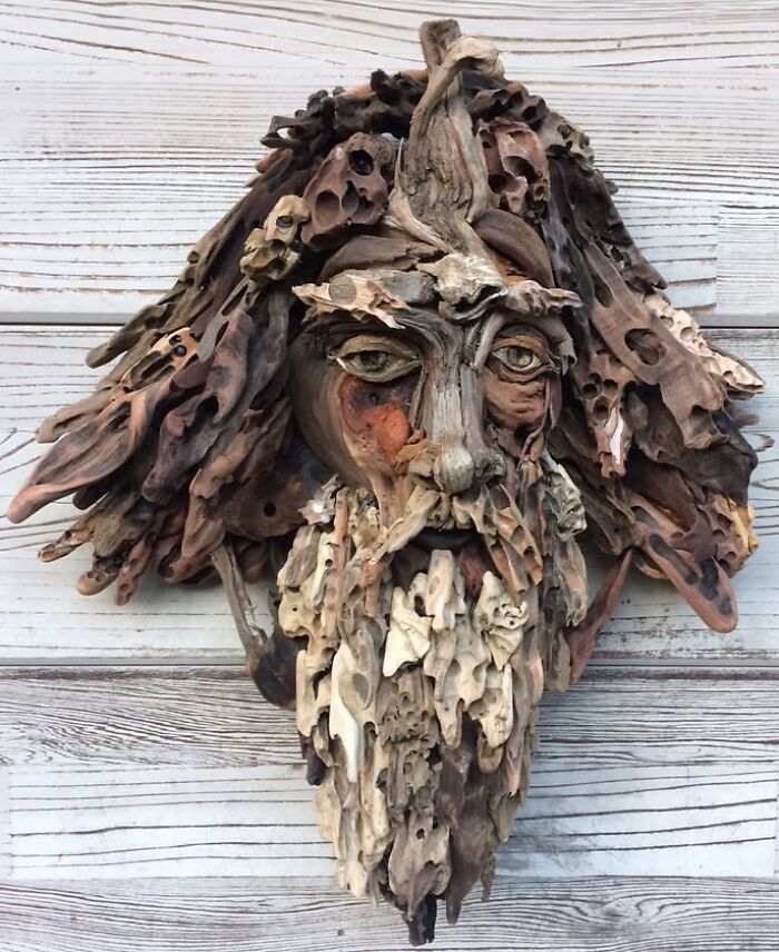 A stunning sculpture of a man's face with a beard and hair made from collected pieces of wood.