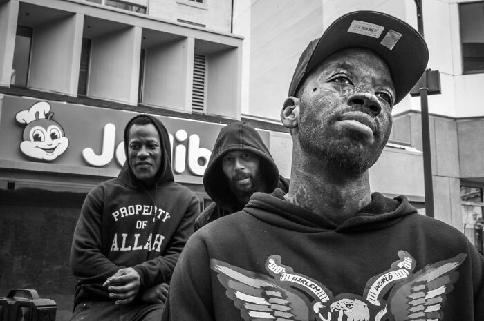 A photographer captures humor and chaos in everyday life, featuring three men in black and white.