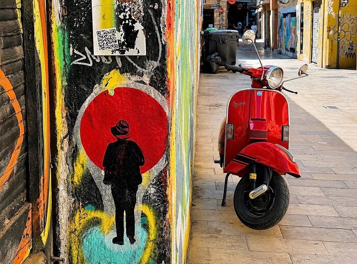 Photographer captures perfectly timed coincidences of a red scooter and street art in Barcelona.