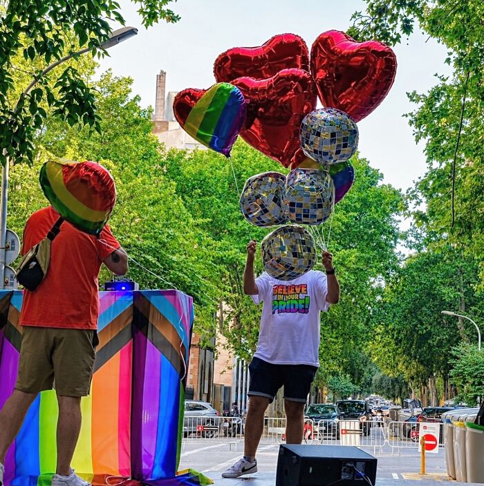 A photographer captures perfectly timed coincidences of a man with heart-shaped balloons, and another with a rainbow flag in Barcelona.