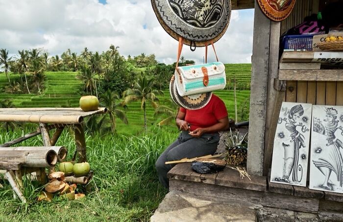 A woman sits by a street stall with perfectly timed street photos revealing extraordinary moments in everyday life.