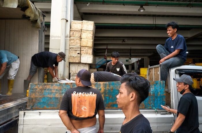 Perfectly timed street photo of workers loading a truck, revealing an extraordinary moment of daily labor.