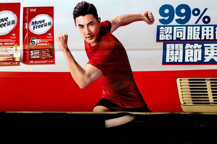 A man on an advertisement appears to be running on the street, a humorous street coincidence.