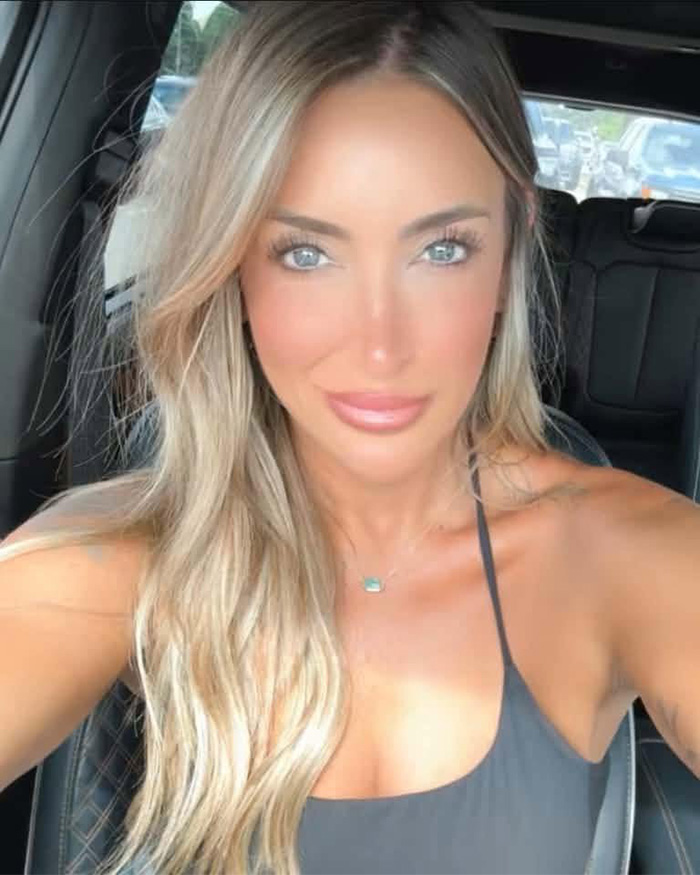 Influencer with long blonde hair and bright blue eyes, wearing a black top, after exposing husband on TikTok.