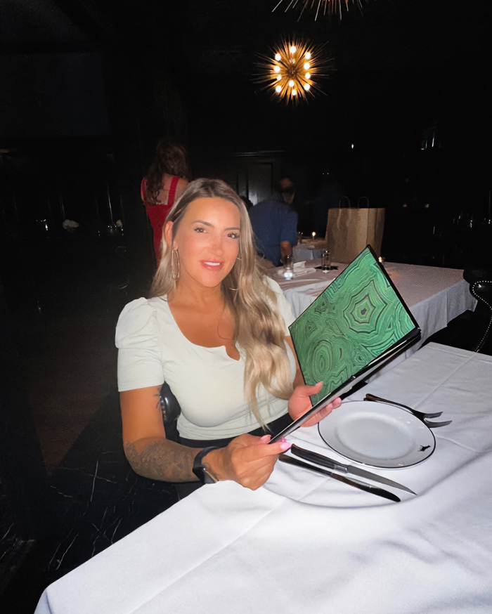 Influencer in a restaurant, holding a menu. This image relates to the story of an influencer and her husband.