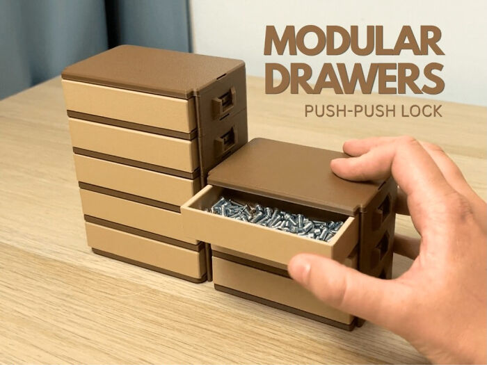 A hand opening a drawer of a 3D printed modular drawer system, filled with small metal screws.