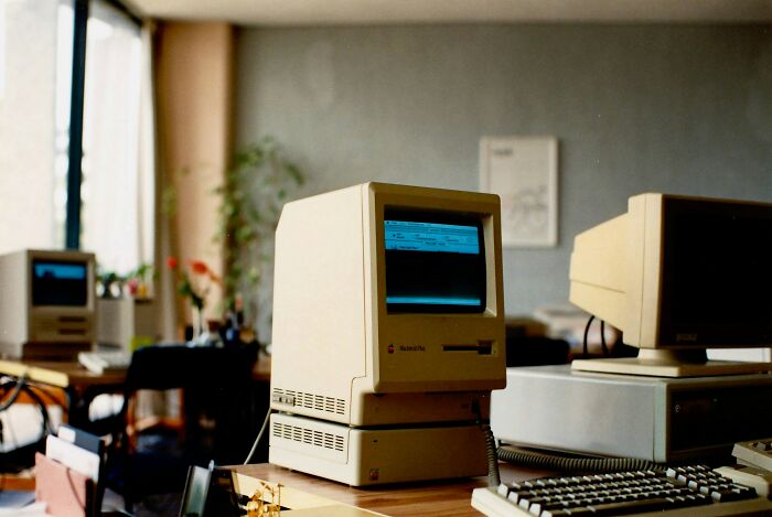 Vintage Macintosh computers in an office, symbolizing early internet rabbit holes and cults.