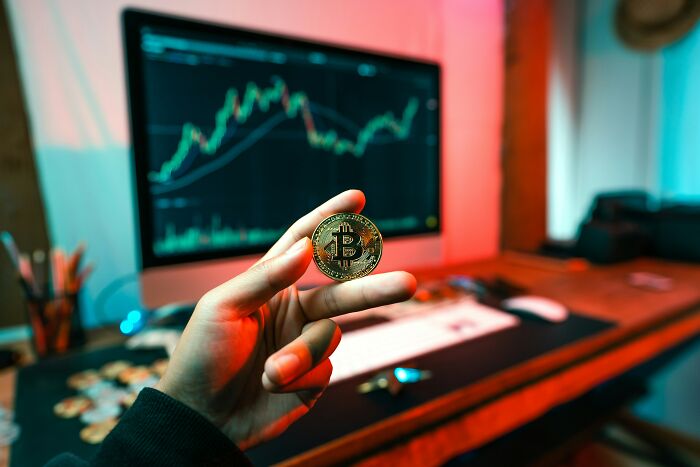 A hand holding a bitcoin, representing internet rabbit holes and digital cults that leave people deeply disturbed.