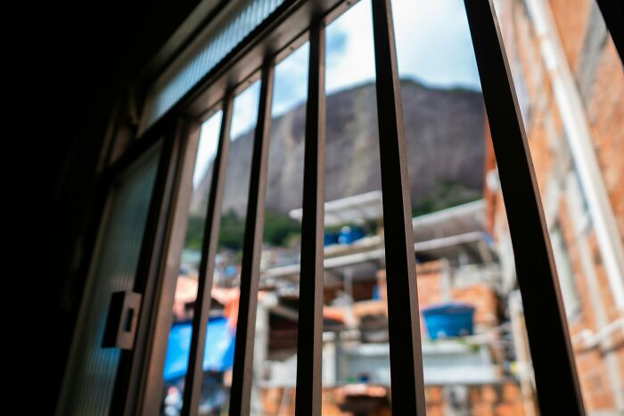 Looking through prison bars at a cityscape, highlighting the disturbing aspects of cults.