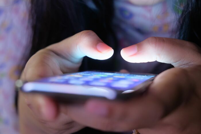 A person with glowing fingers using a smartphone, exploring internet rabbit holes and the topic of cults.