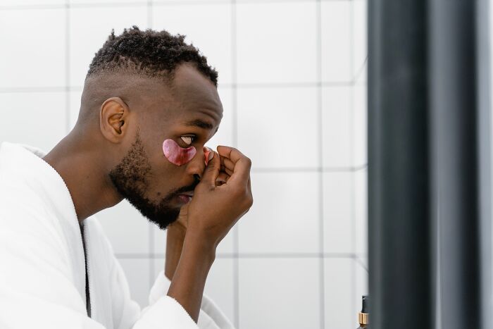 Man applying under-eye patches, exploring deep internet rabbit holes.
