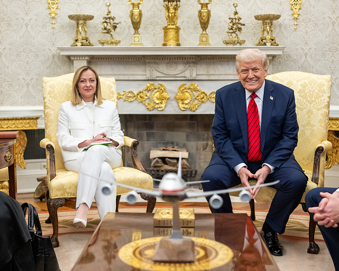 Italian PM Giorgia Meloni and Trump seated in a room, with a model airplane on the table, discussing NATO. Italian PM Giorgia Meloni and Trump seated in a room, with a model airplane on the table, discussing NATO.