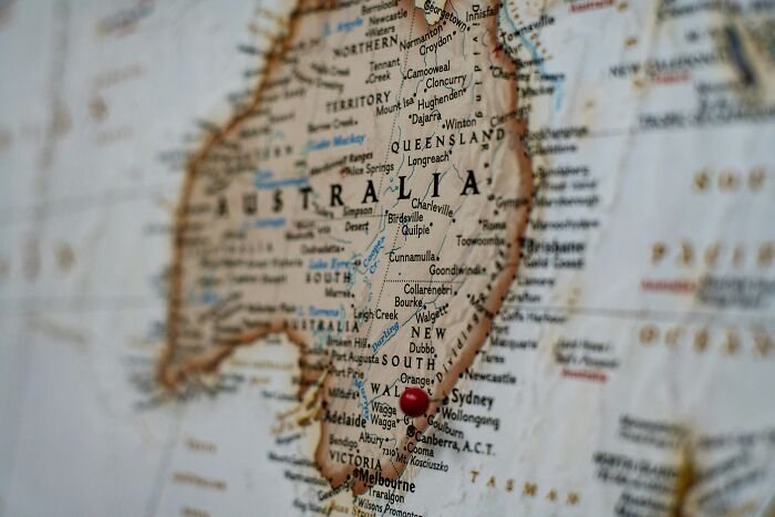A close-up of Australia on a world map with a red pin on Sydney, highlighting infuriating mansplaining locations.