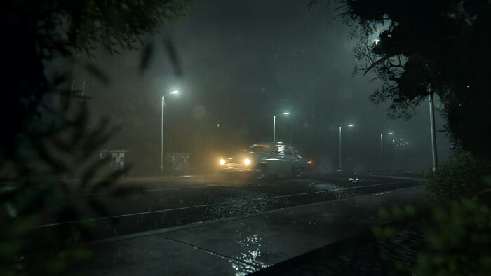 A car driving through a misty, rainy night, a scary and disturbing scene in public.
