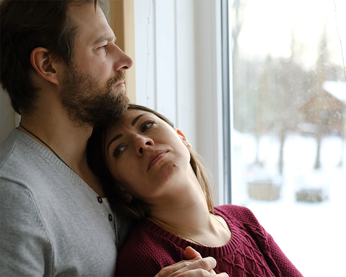 A couple looking out a window, appearing to be contemplating their libido and relationship issues.