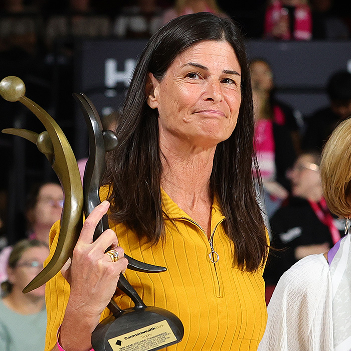 Designer holding an award, responding to backlash over unusual uniforms and wardrobe malfunctions for female athletes.