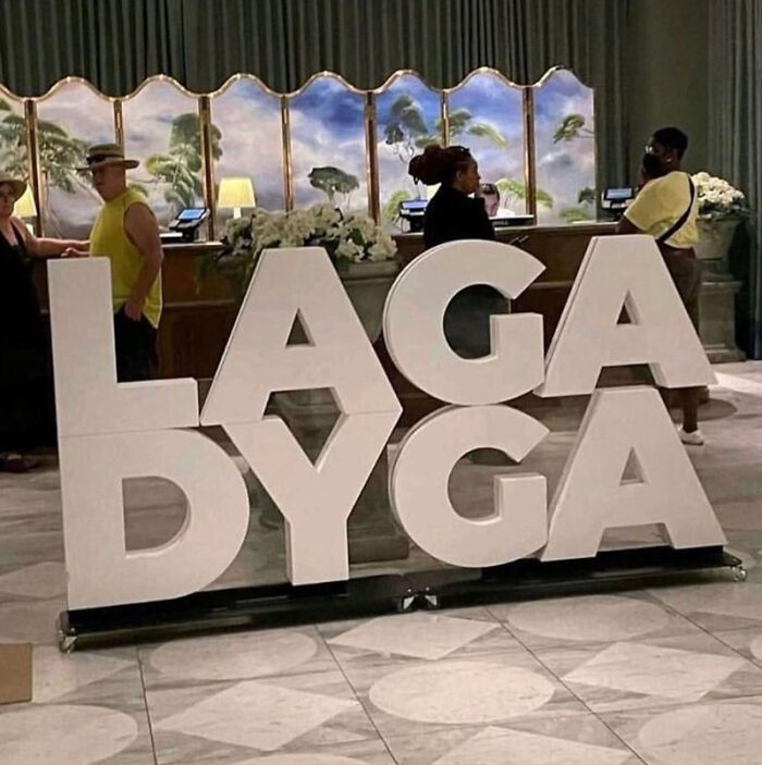 Large white letters on a floor spelling LAGA DYGA, intended to spell LADY GAGA, showing designers failing.