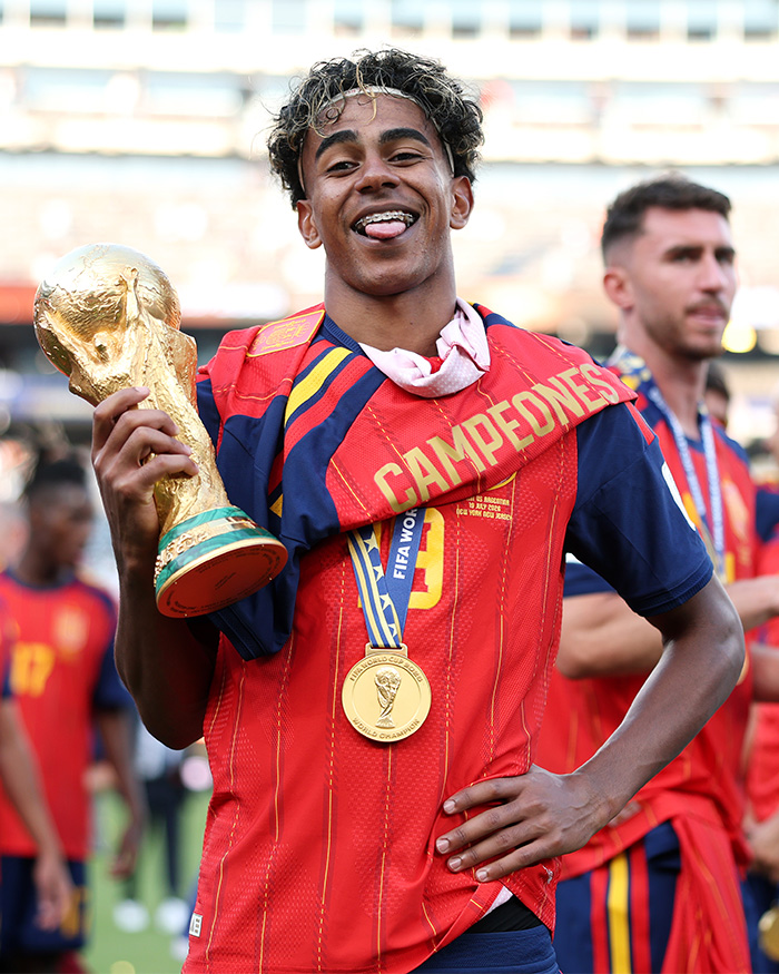 A World Cup hero proudly holds the trophy, celebrating his win with a smile for female fans. A World Cup hero proudly holds the trophy, celebrating his win with a smile for female fans.