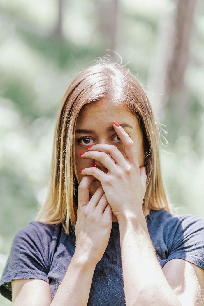 A woman covering her face with her hands, looking deeply evil, symbolizing people's instincts to get away from creeps.