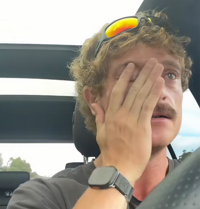 A lonely man with sunglasses on his head, wiping his eye as he makes a crying plea in a car. A lonely man with sunglasses on his head, wiping his eye as he makes a crying plea in a car.