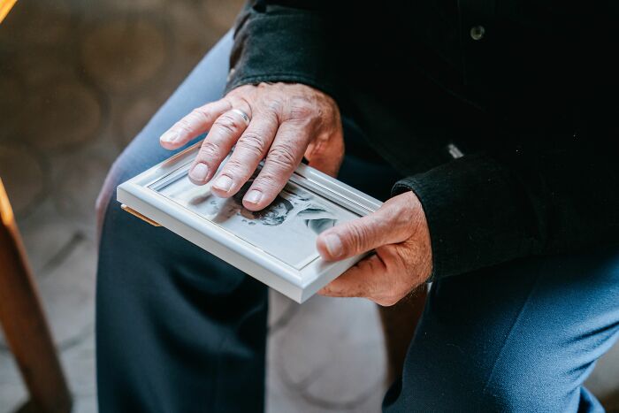 A person holds a framed photo, reflecting on the harsh realities of being married.