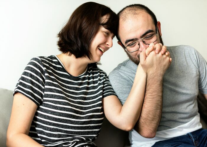A happy couple laughing and holding hands, illustrating the joys of being married.