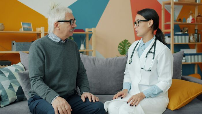 An older man consulting with a female doctor, discussing the realities of being married.