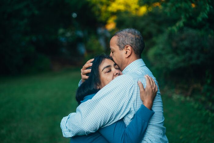 A middle-aged couple sharing a tender hug outdoors, depicting the realities of being married.