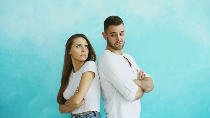 A married couple standing back-to-back, looking upset, illustrating the harsh realities of being married.