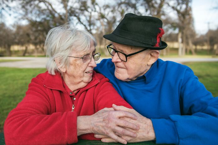 An elderly married couple holding hands, reflecting the realities of being married.