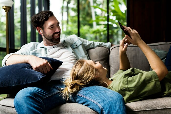 A happy young couple enjoying a quiet moment together on the couch, showing the realities of being married.