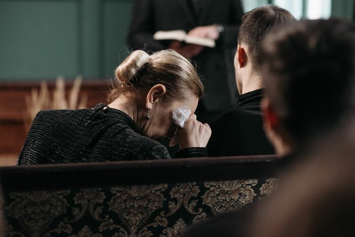 A woman crying during a funeral, symbolizing the harsh realities of being married.