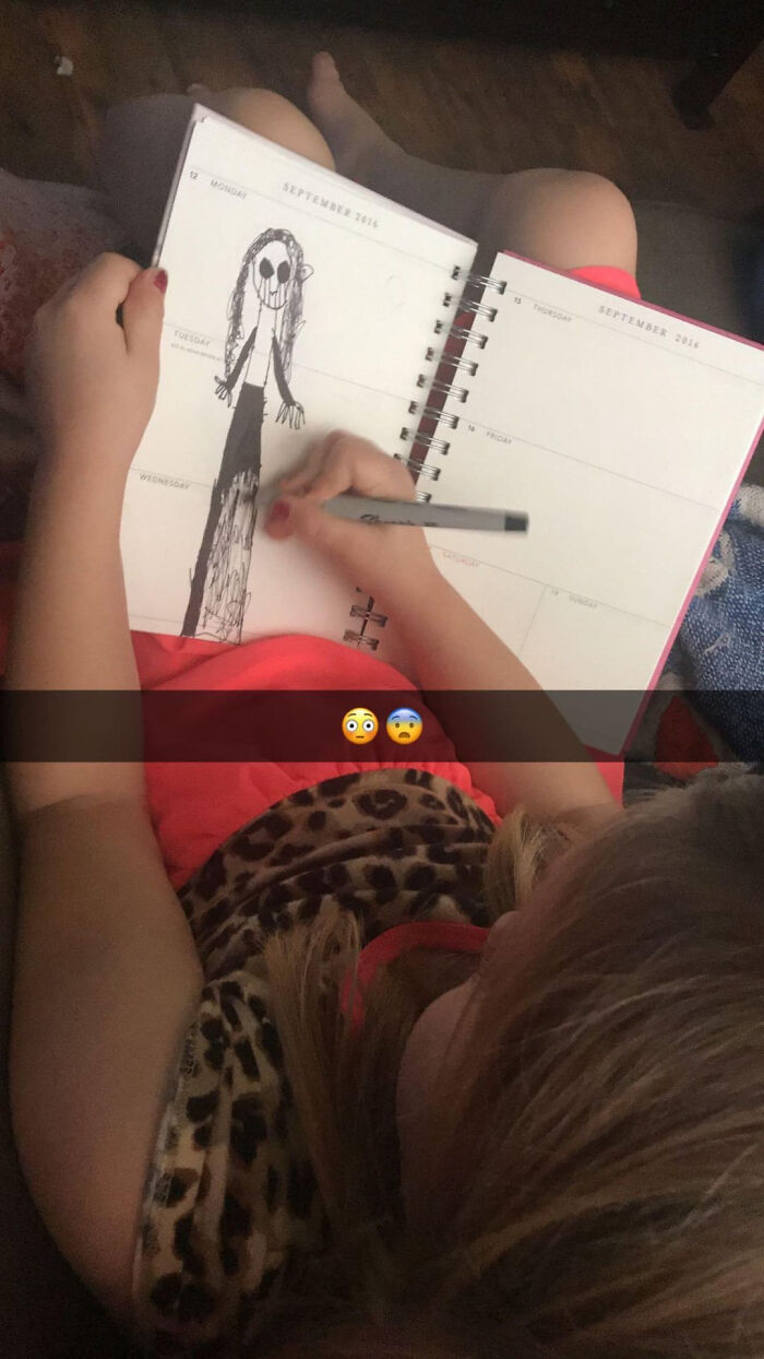 A young child drawing a scary figure in a notebook, a scene that makes parents terrified.